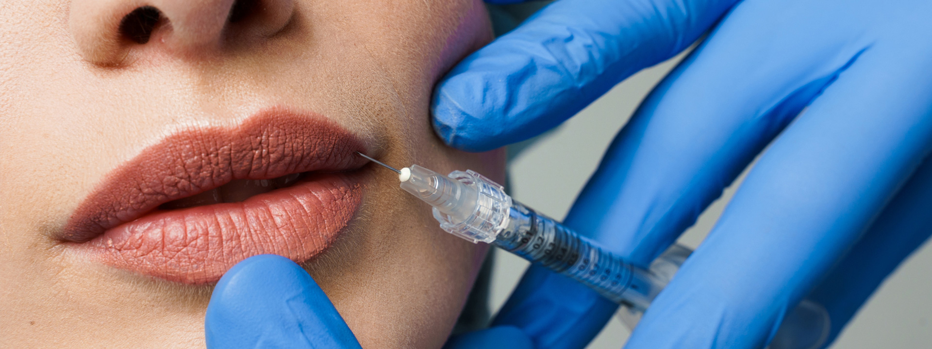 A beautiful woman is receiving a dermal filler treatment.